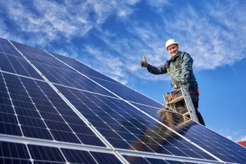 Ein Installateur begutachtet neu installierte Solarmodule und vergewissert sich von der Leistungsfähigkeit der Module.